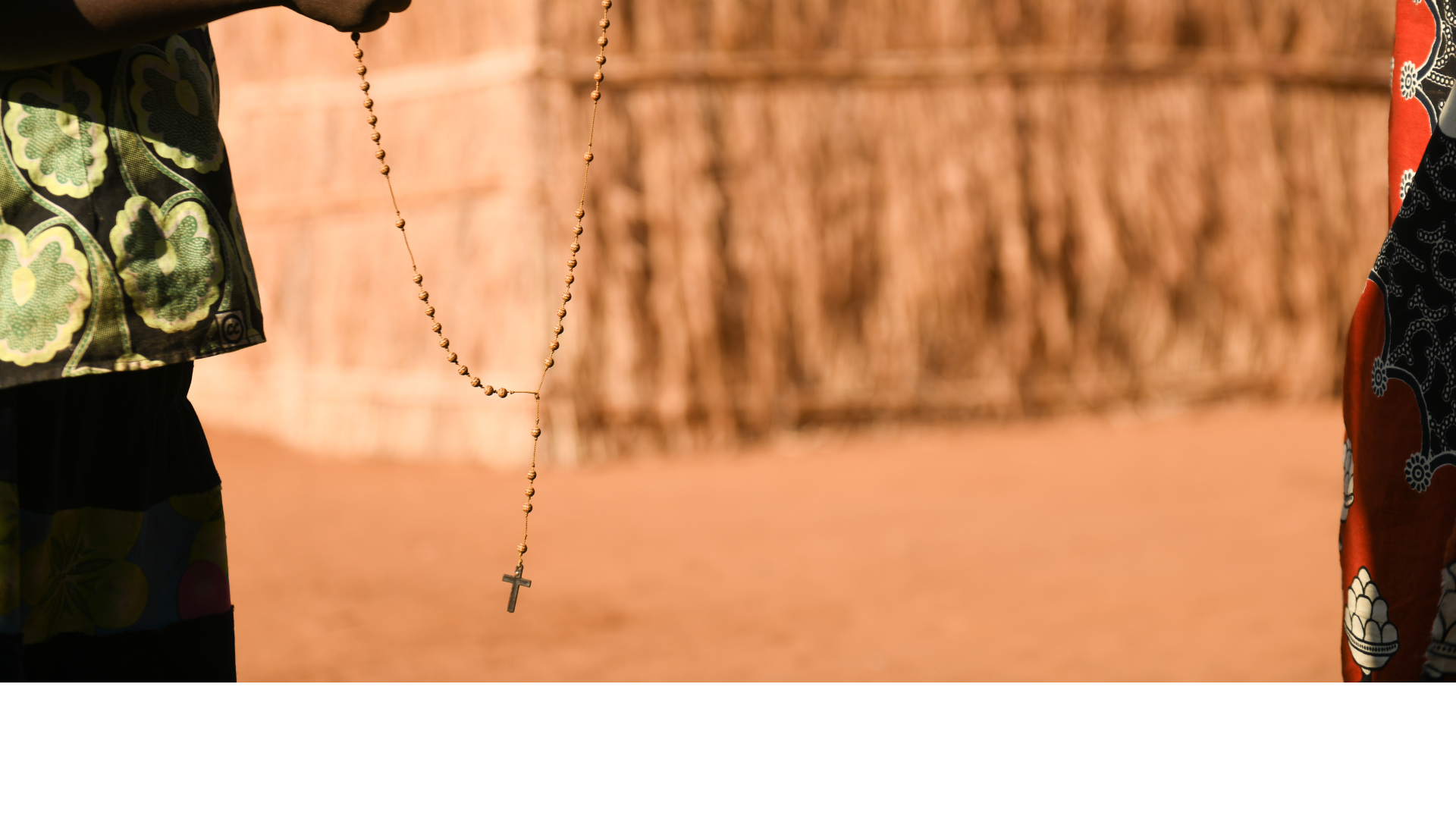 Two hands holding Rosary Beads