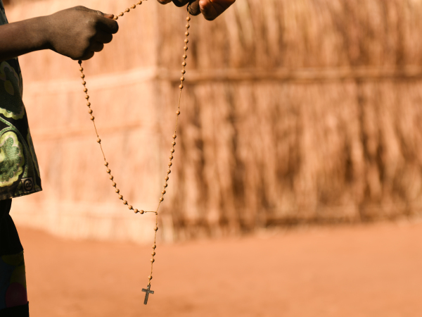 Two hands holding Rosary Beads