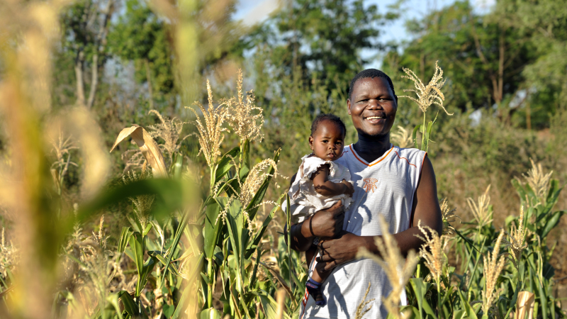 Joseph and his daughter in Malawi smiling at the camera
