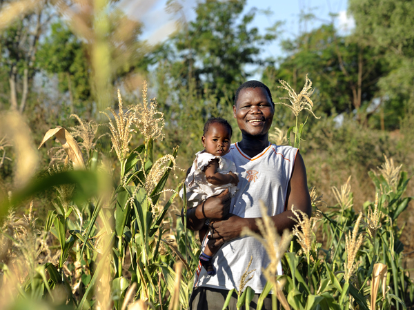 Joseph and his daughter in Malawi smiling at the camera