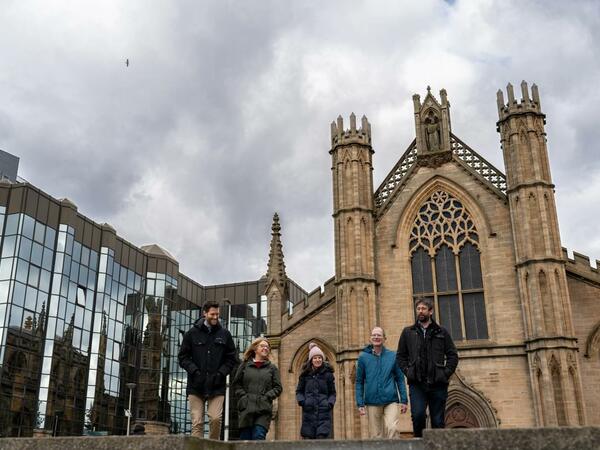 Group of people walking past a cathedral