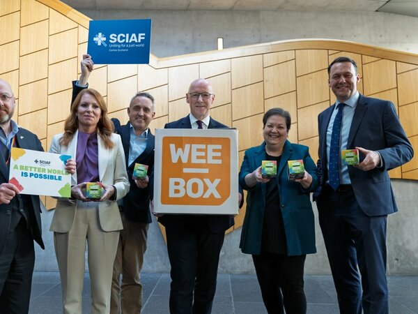 MSP's standing together in Holyrood with WEE BOX signs