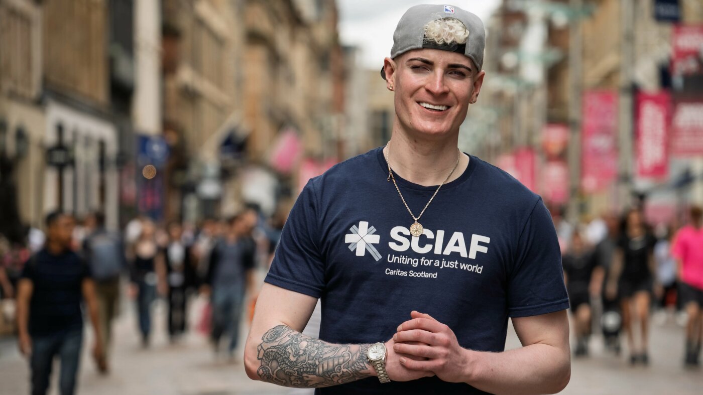 Man smiling at camera on busy street